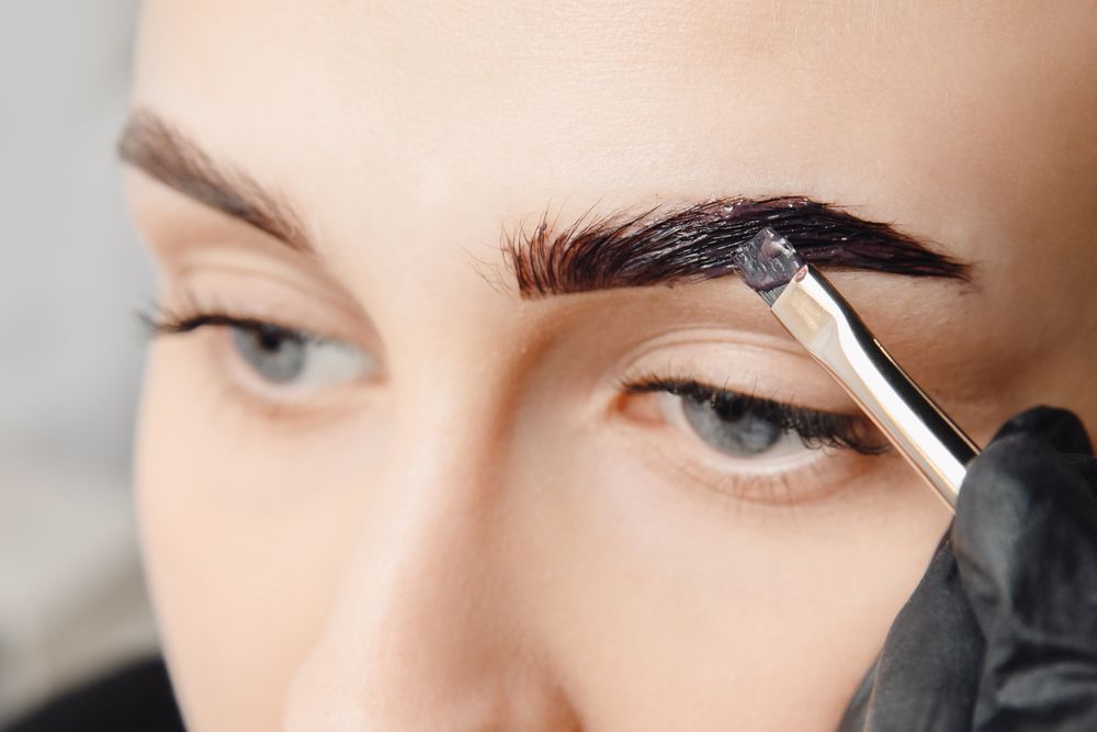 Person Applying Eyebrow Dye With a Brush — Bombshell Body Bar In Meikleville Hill, QLD