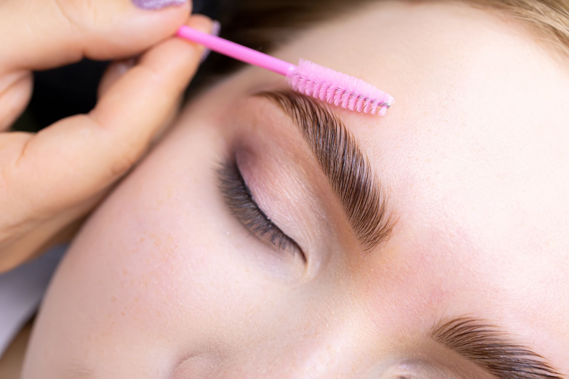 Close-up of a Person Getting Their Eyebrows Brushed With a Pink Brush — Bombshell Body Bar In Meikleville Hill, QLD