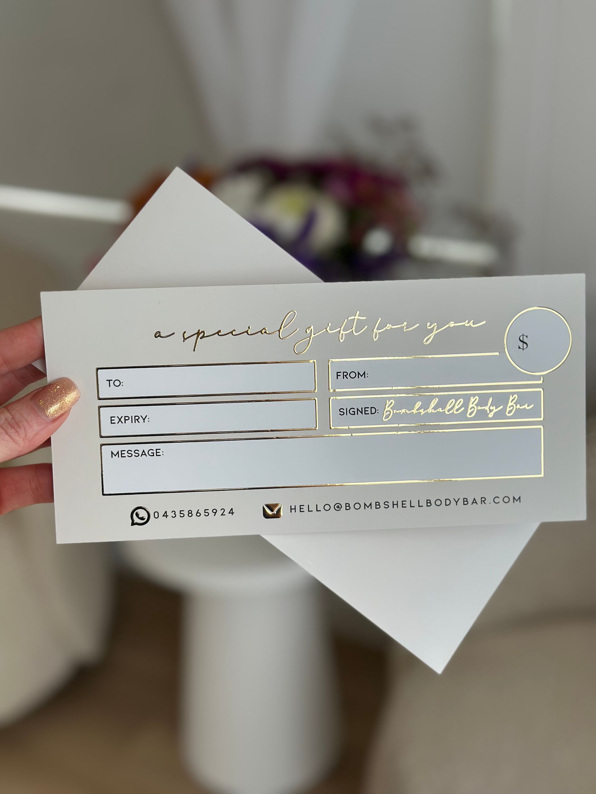 A Hand Holding a Gift Certificate on White Paper With a White Envelope — Bombshell Body Bar In Meikleville Hill, QLD