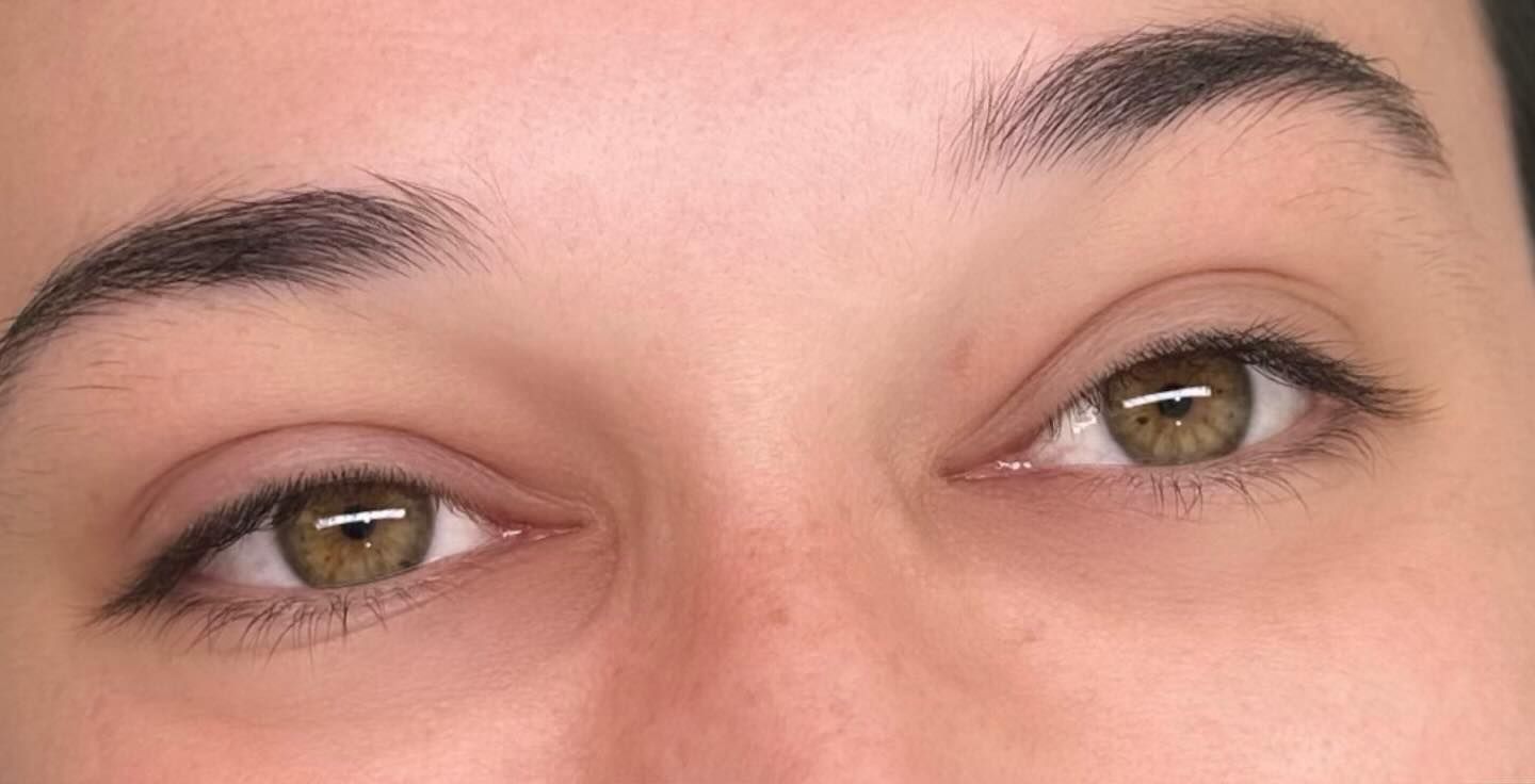 Close-up of two green eyes with dark eyebrows, looking towards the upper right.