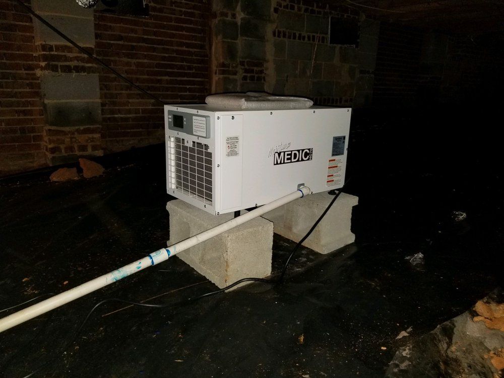 A white machine is sitting on top of concrete blocks in a dark room.