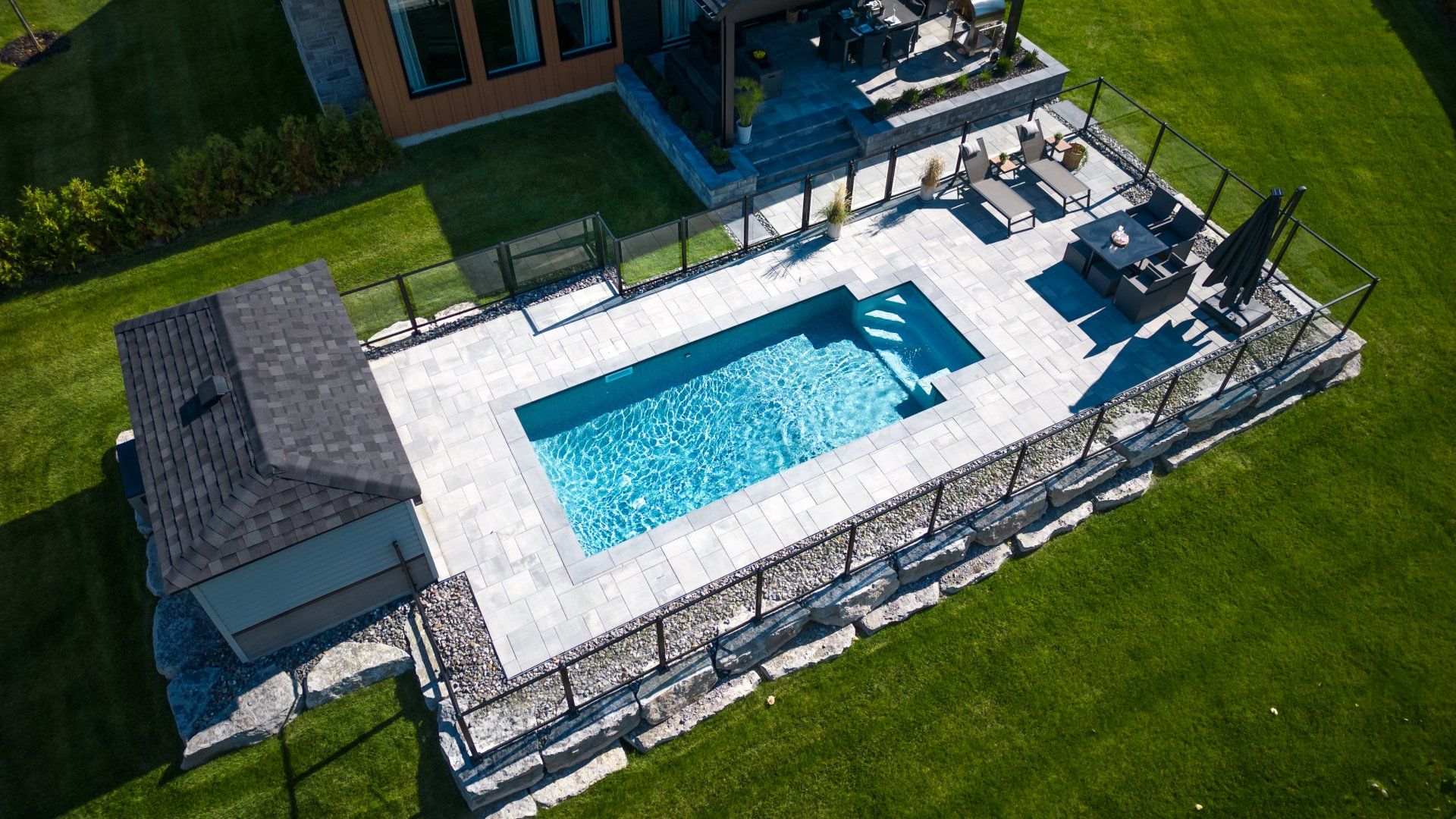 Une vue aérienne d'une grande piscine dans une cour arrière à côté d'une maison.