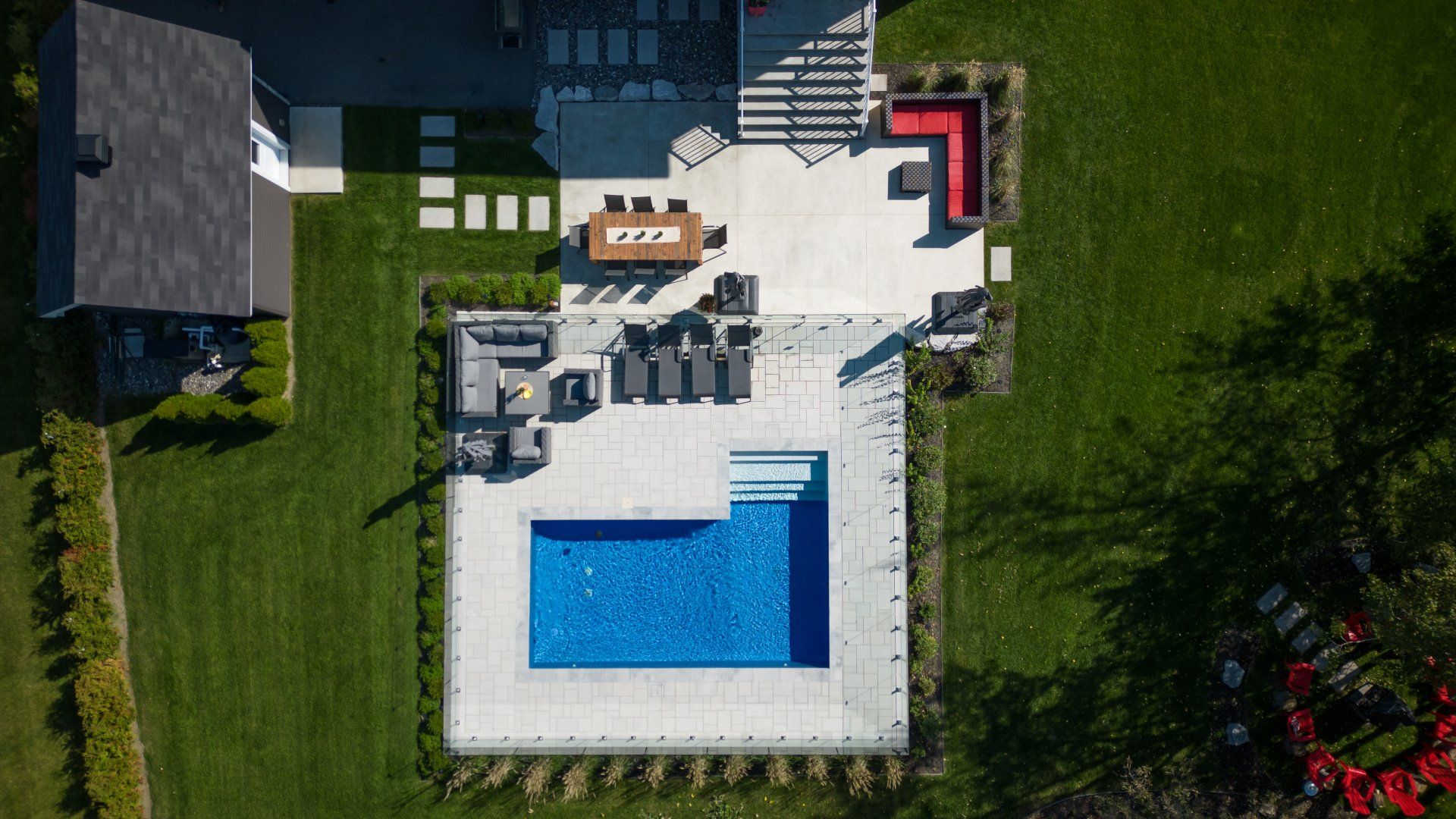 Une vue aérienne d'une maison avec piscine et mobilier de jardin.