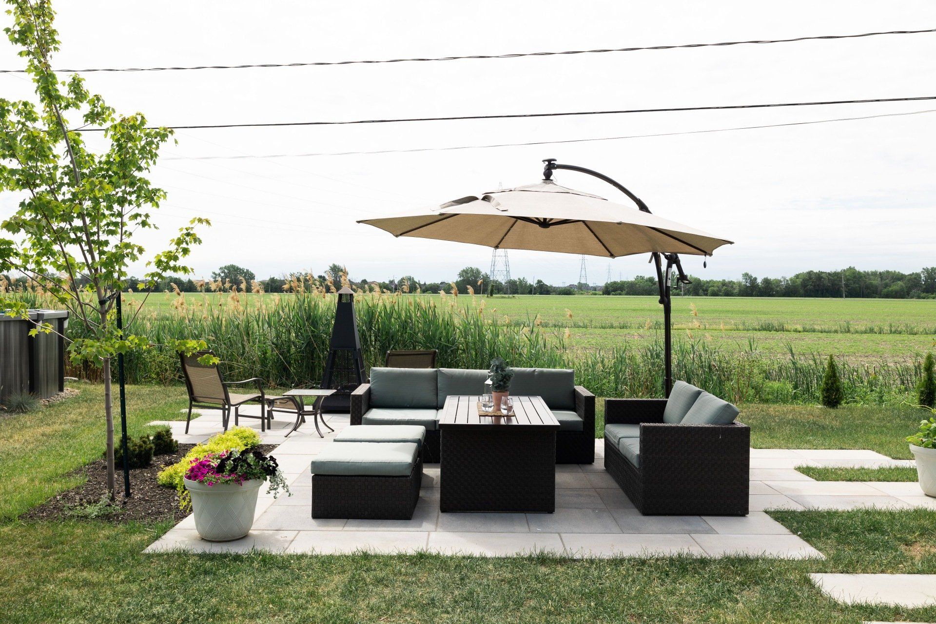 Un patio avec un canapé, une table, des chaises et un parasol.