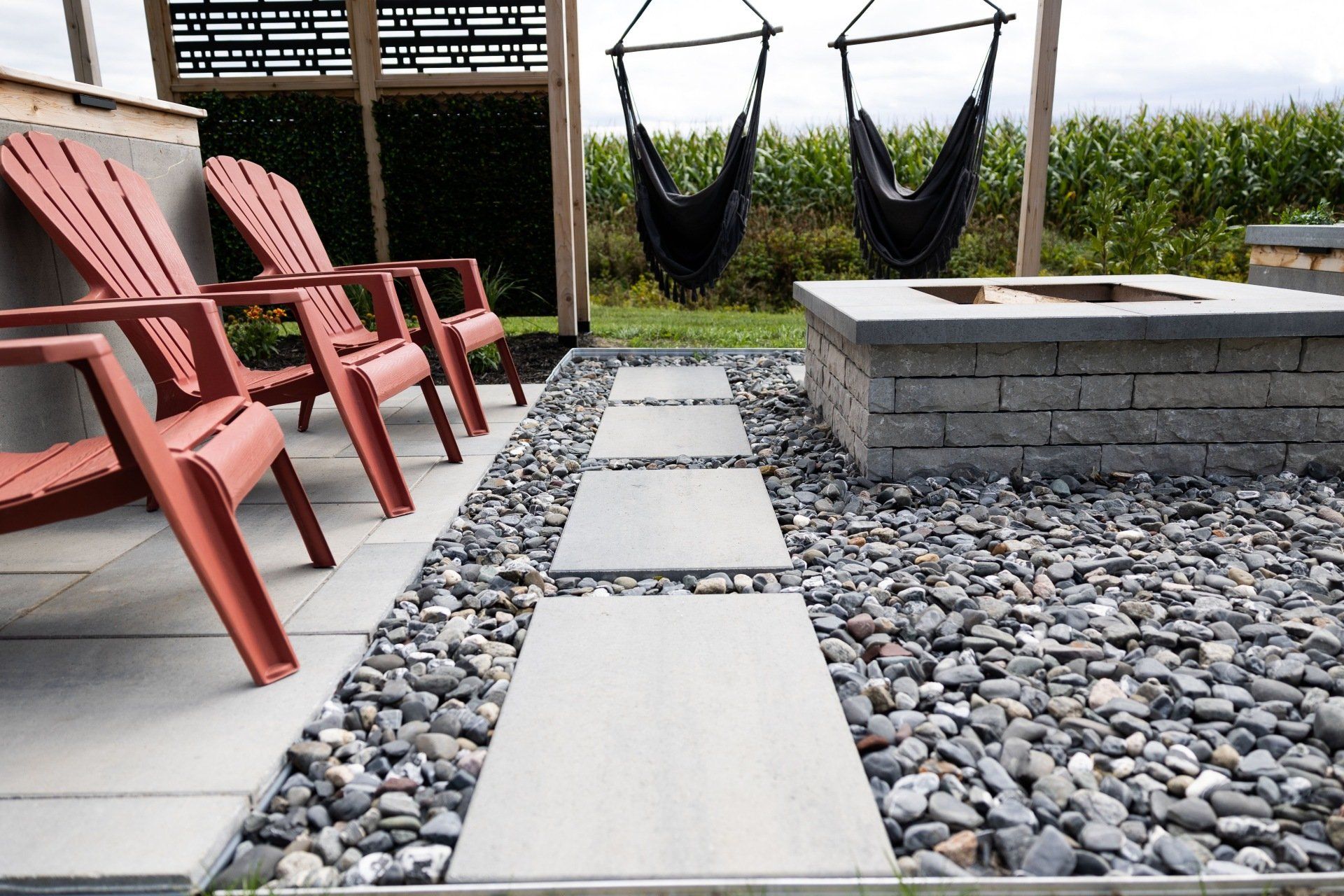 Un patio avec un foyer, des chaises et des hamacs.