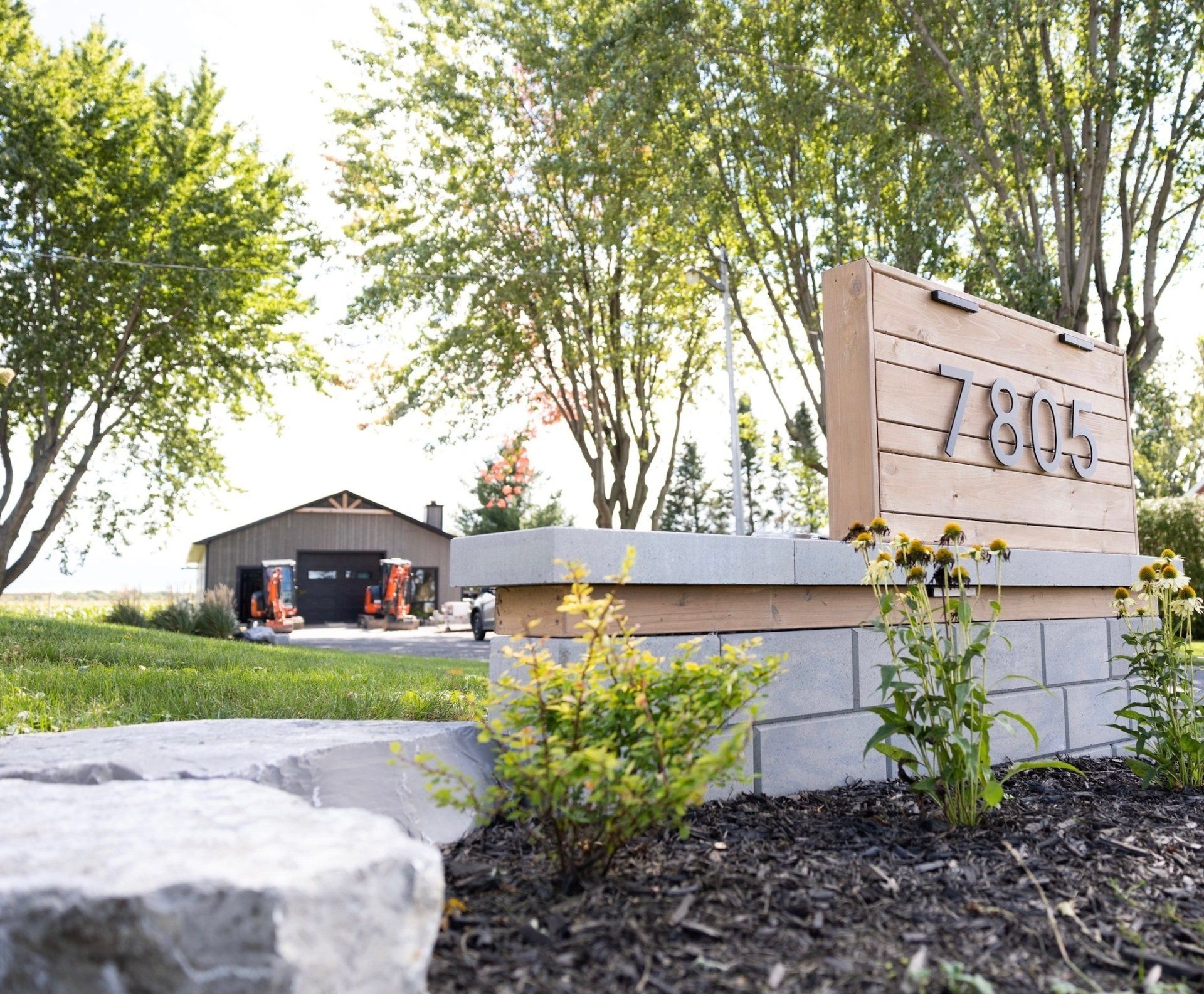 Un panneau en bois avec le numéro 784 dessus se trouve devant une maison.