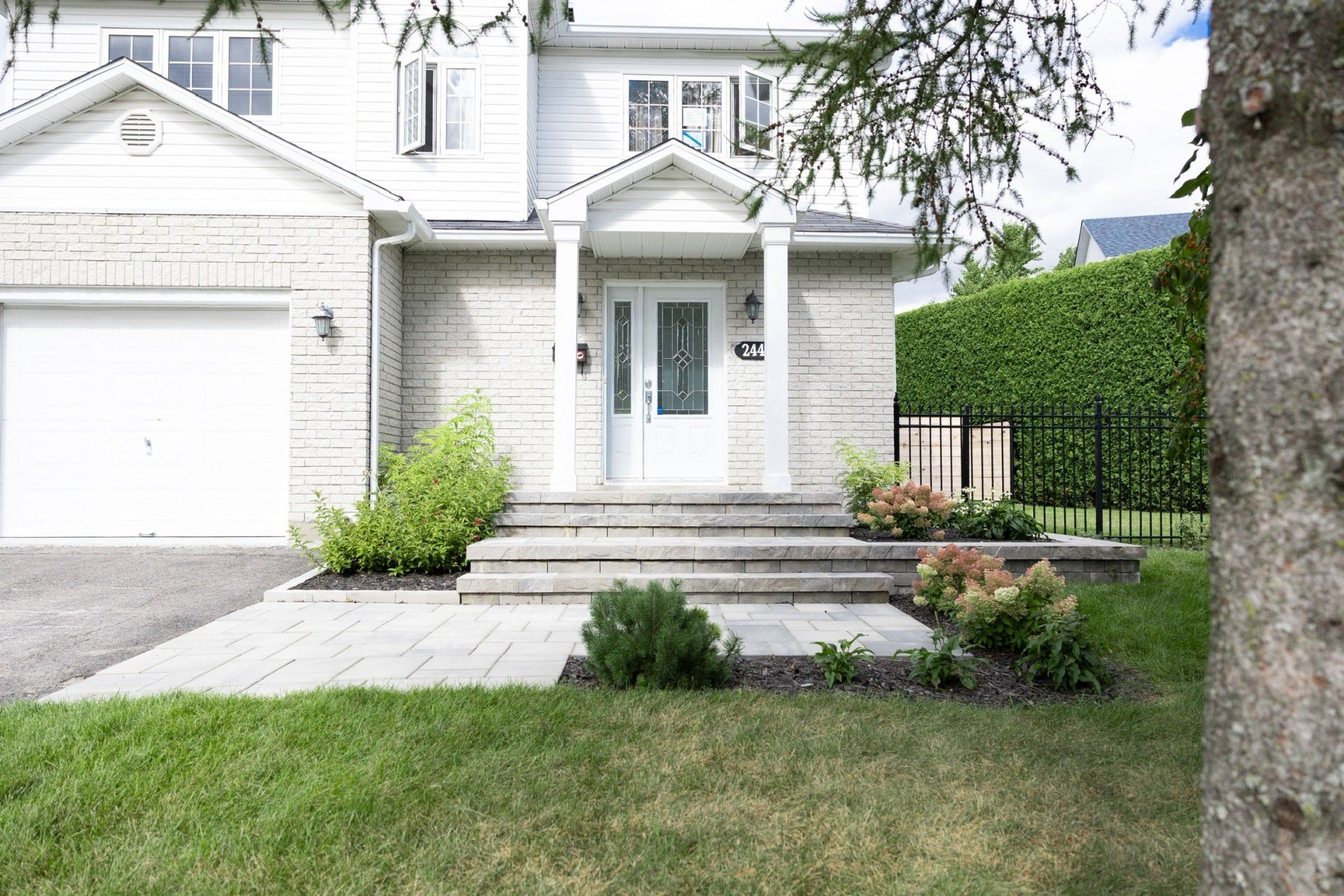 Une maison blanche avec un arbre devant