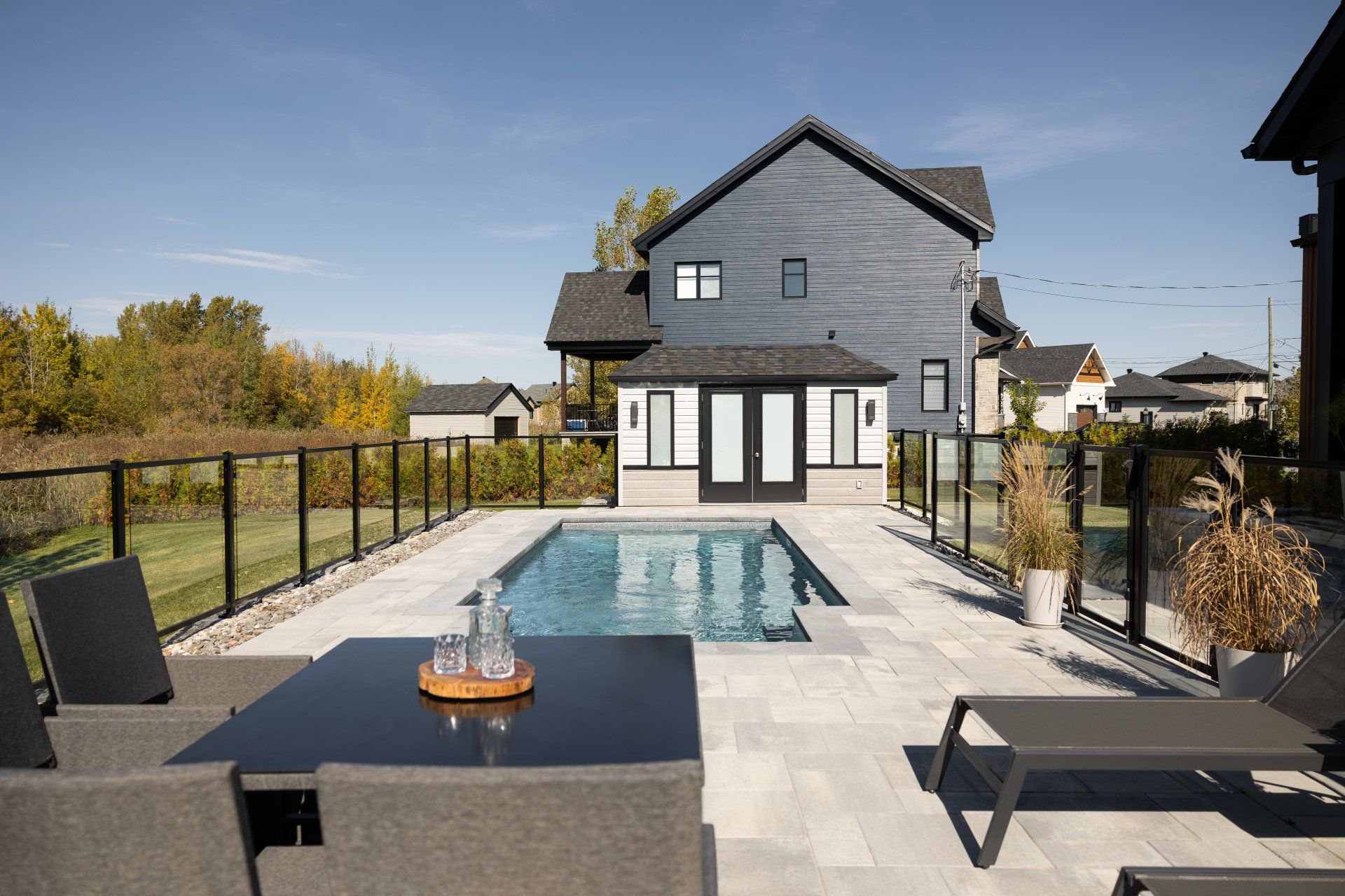 Il y a une grande piscine dans l'arrière-cour d'une maison.