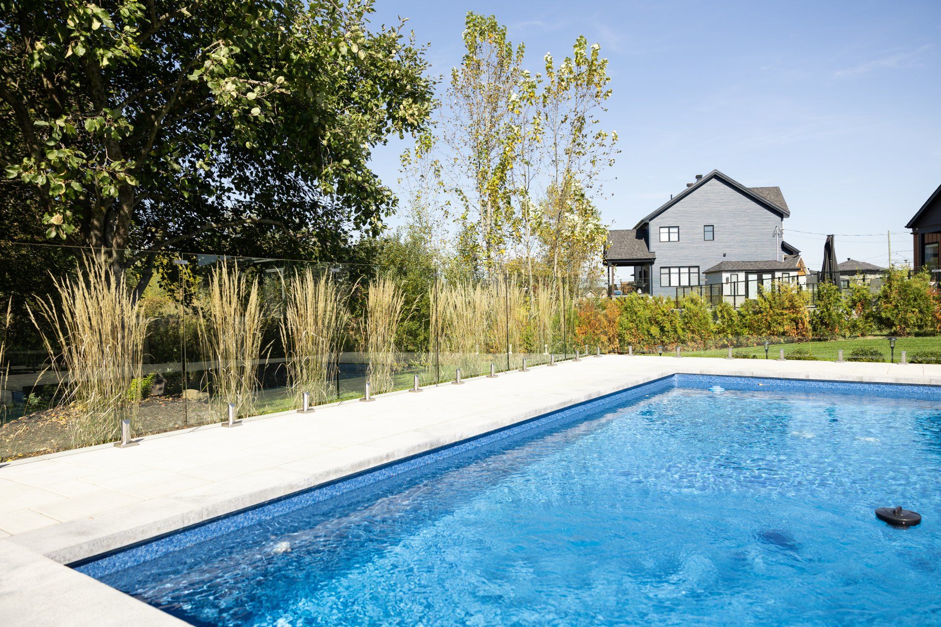 Une grande piscine avec une maison en arrière-plan