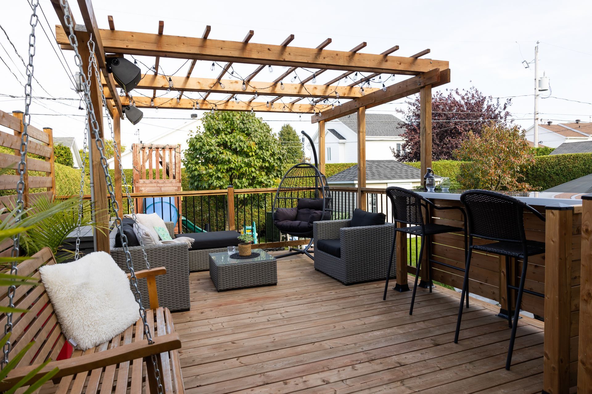 Une terrasse en bois avec une pergola et des meubles de jardin.