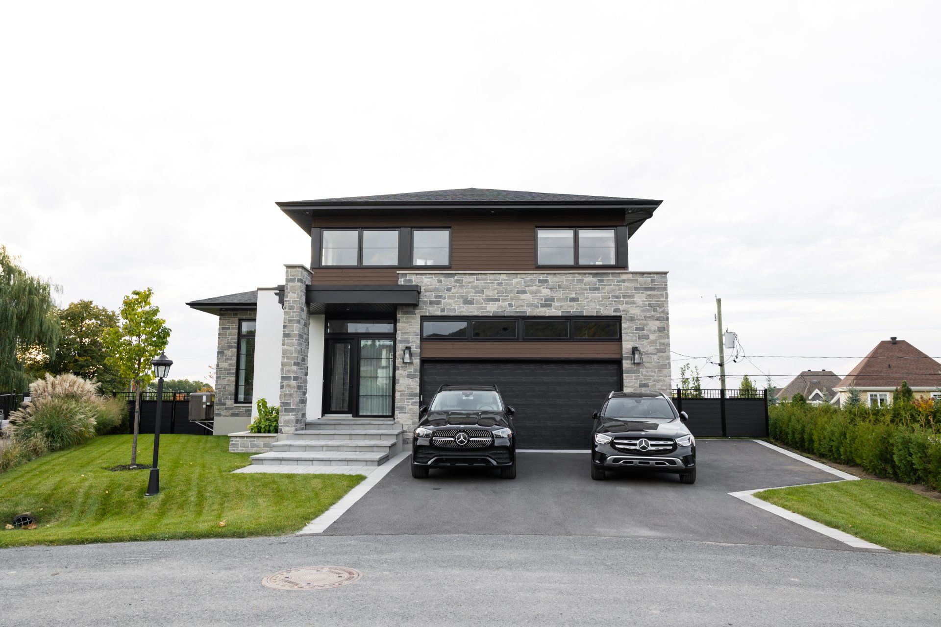 Deux voitures sont garées devant une grande maison.