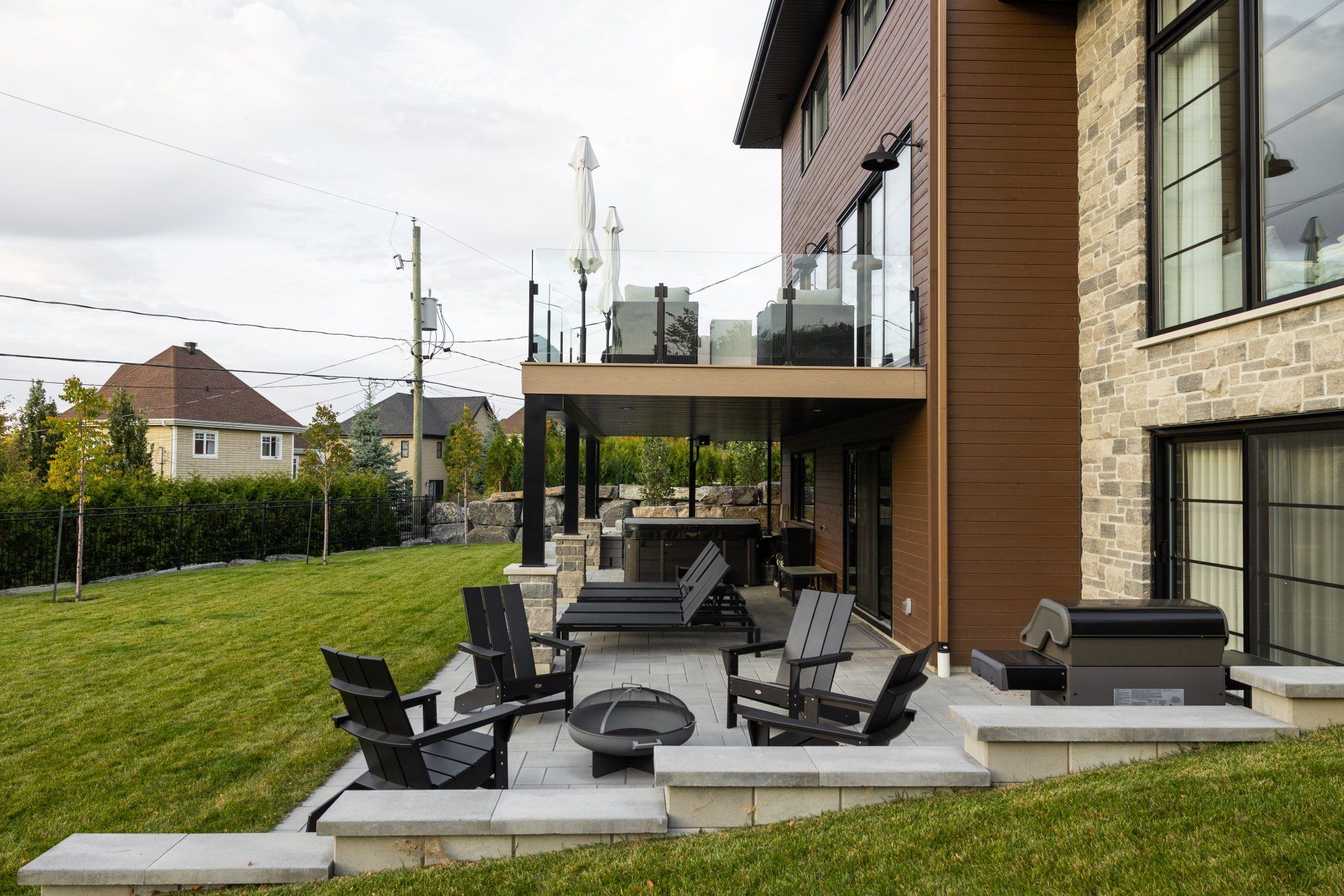Une grande maison avec un patio et des chaises devant.