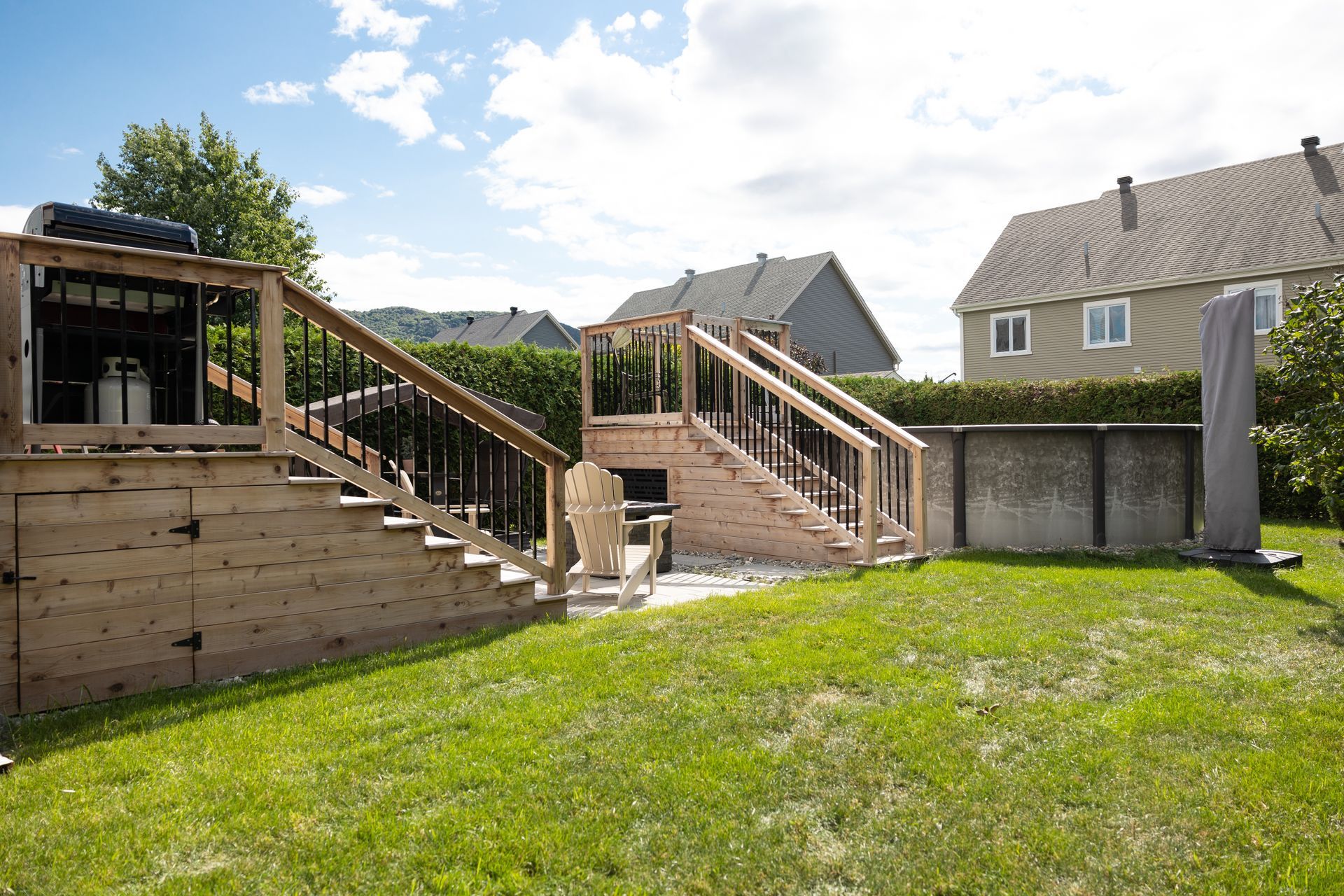 Une cour arrière avec une terrasse en bois et des escaliers