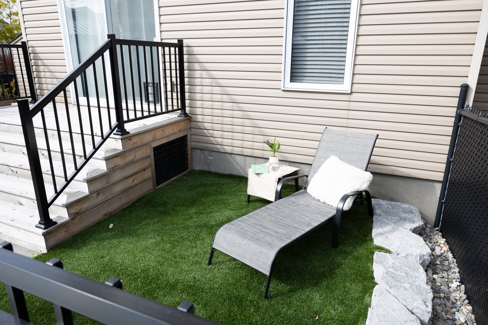 Une chaise de jardin est posée sur une pelouse verte luxuriante devant une maison.
