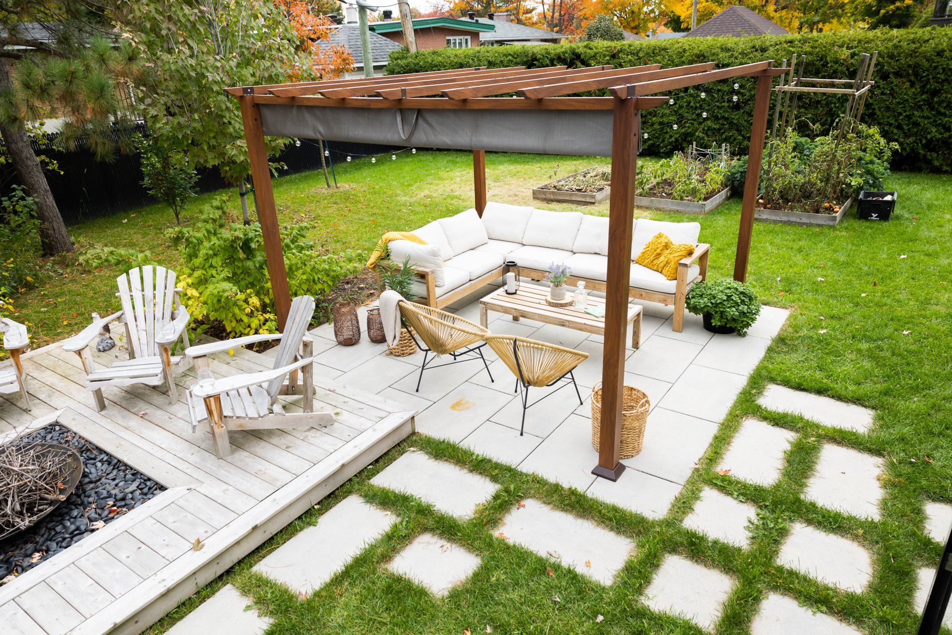 Un patio avec une pergola, un canapé, des chaises et un foyer.
