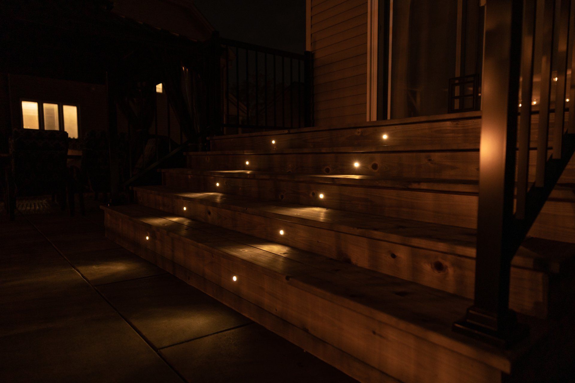 Un ensemble d'escaliers en bois avec des lumières dessus la nuit.