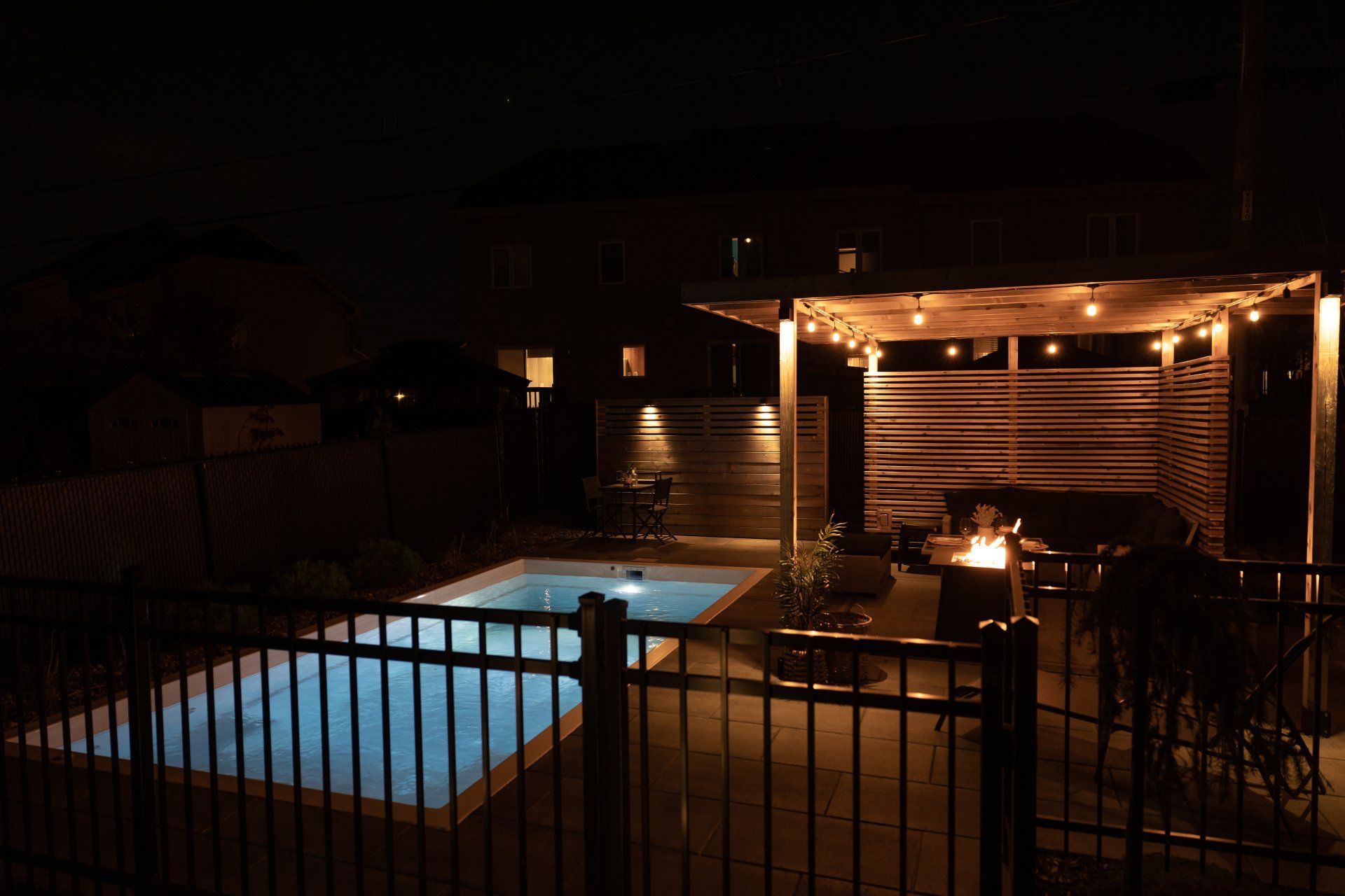 Une grande piscine est entourée d'une clôture la nuit.