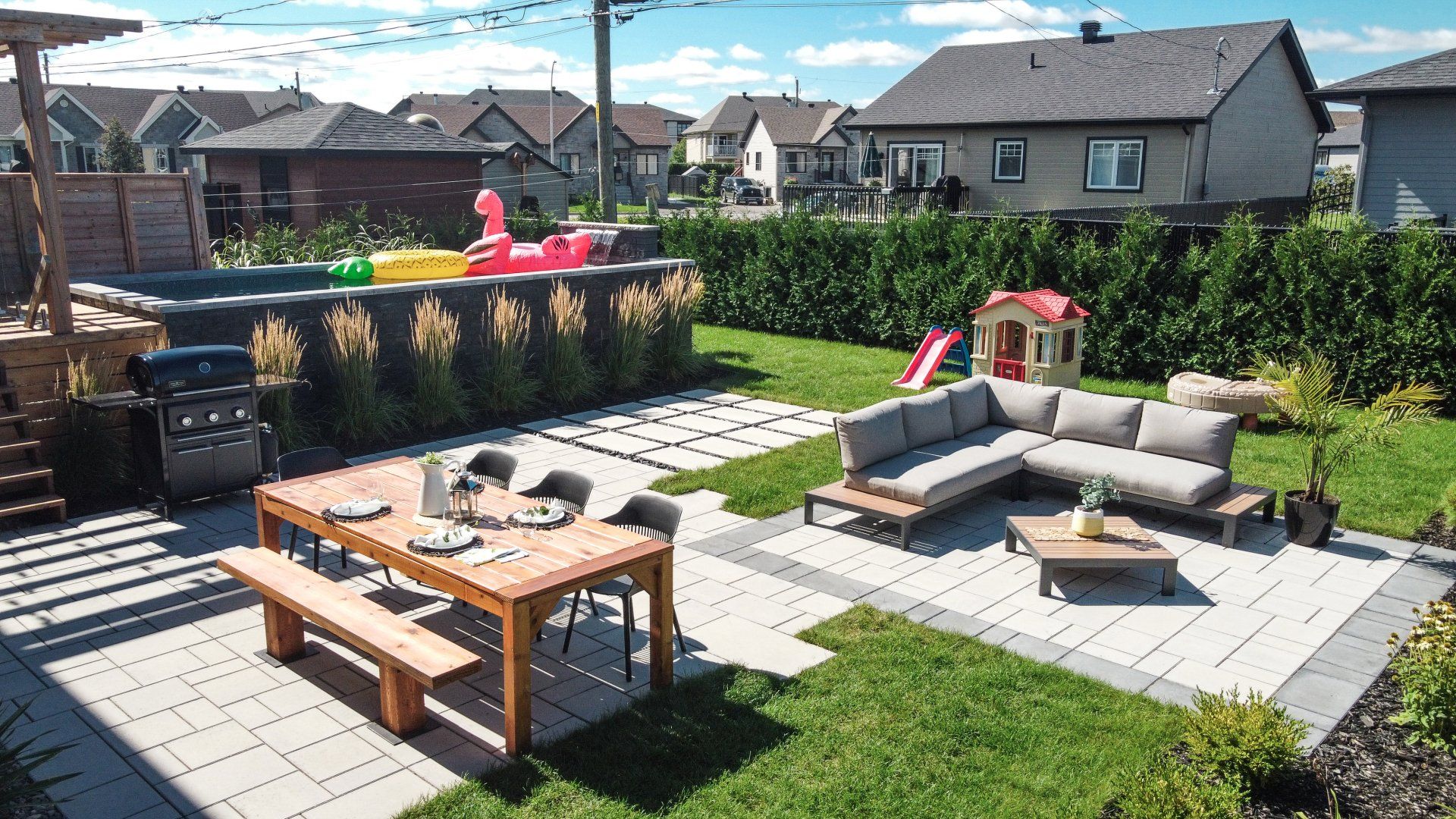 Une cour arrière avec une table, des bancs et une piscine.