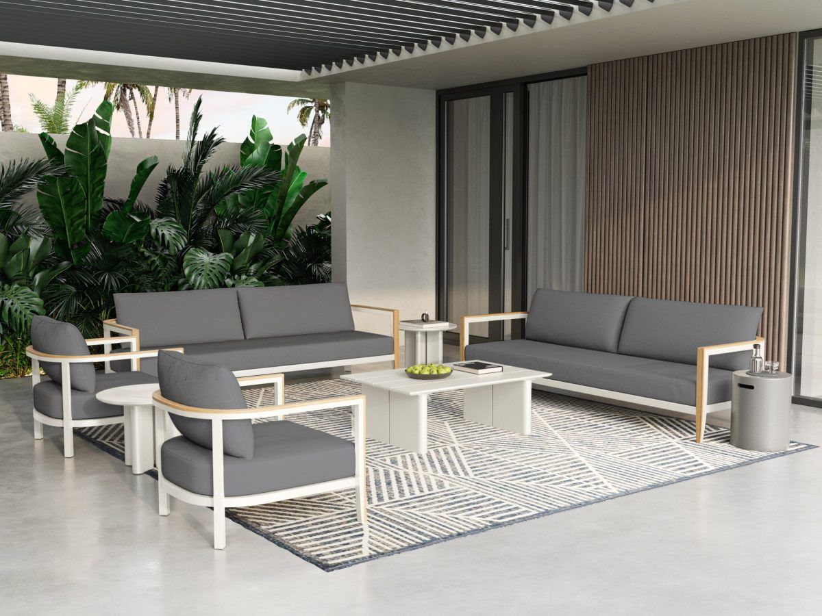 Ensemble de patio extérieur avec coussins gris, cadre blanc, tapis et table basse.