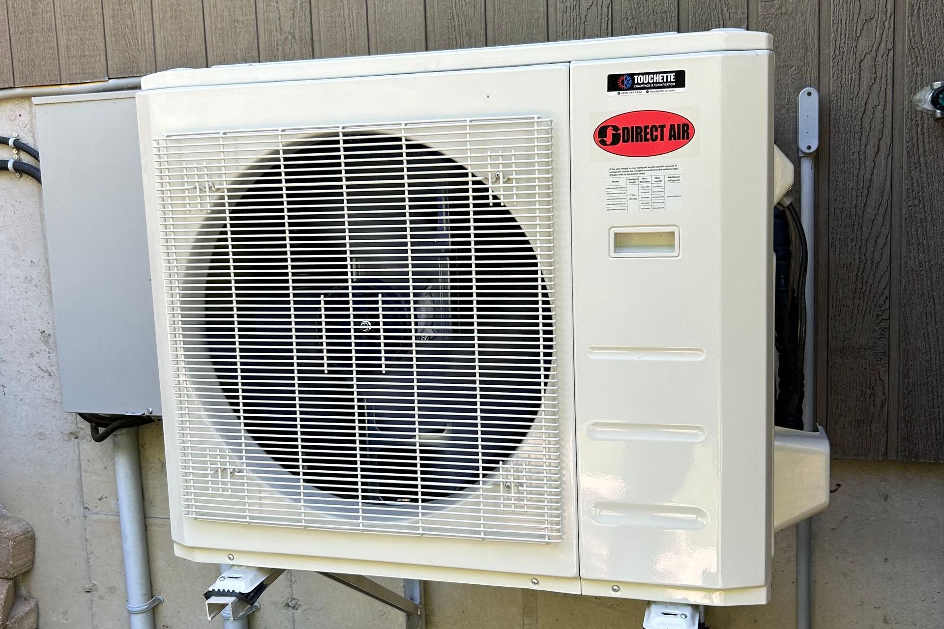 Climatiseur extérieur beige avec pales de ventilateur floues par le mouvement.