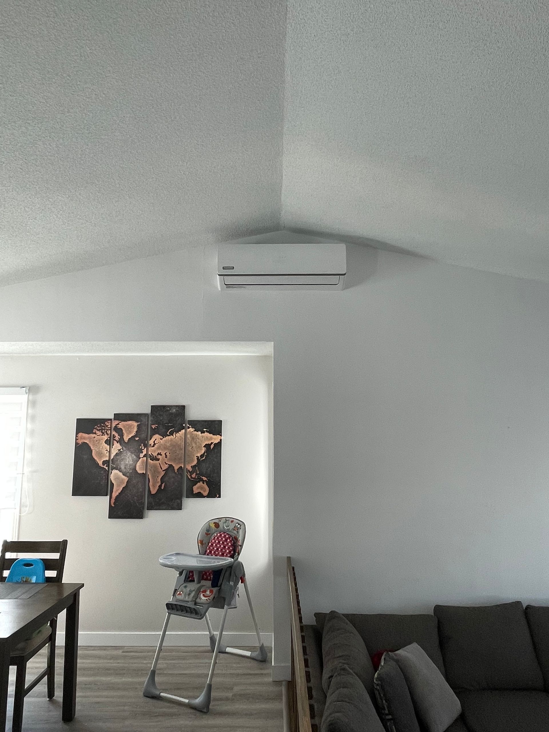 Un séjour avec un canapé, une table, des chaises et une chaise haute.