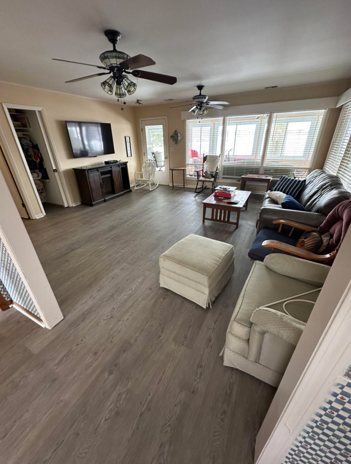Hardwood floor, dark gray walls, and natural light coming through windows in a room.