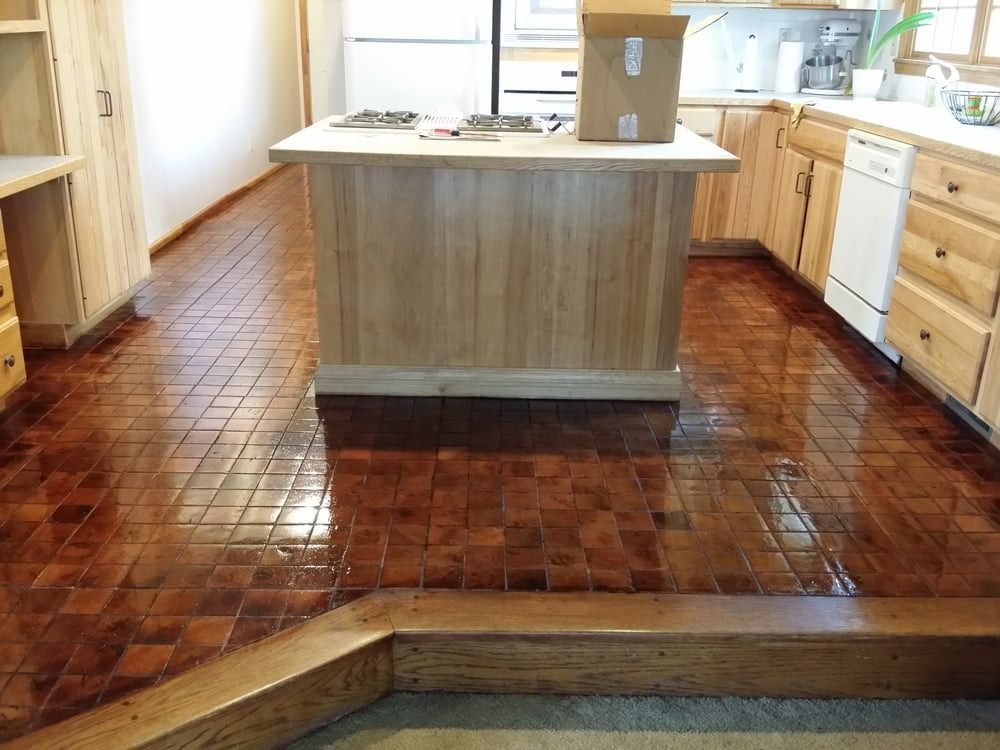 Wooden tile kitchen floor with island and cabinets.