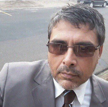 Um homem de terno e gravata está usando óculos escuros