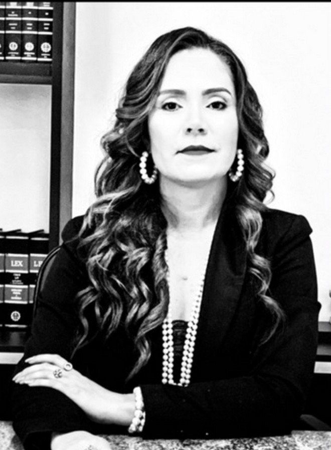 Uma foto em preto e branco de uma mulher sentada em uma mesa