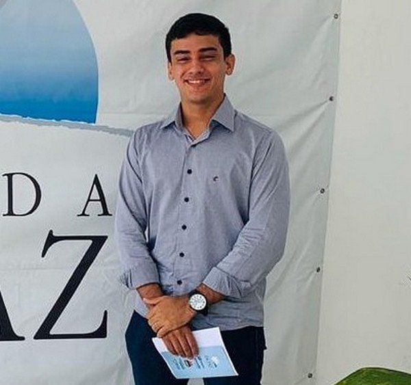 Um homem parado na frente de uma placa que diz da z