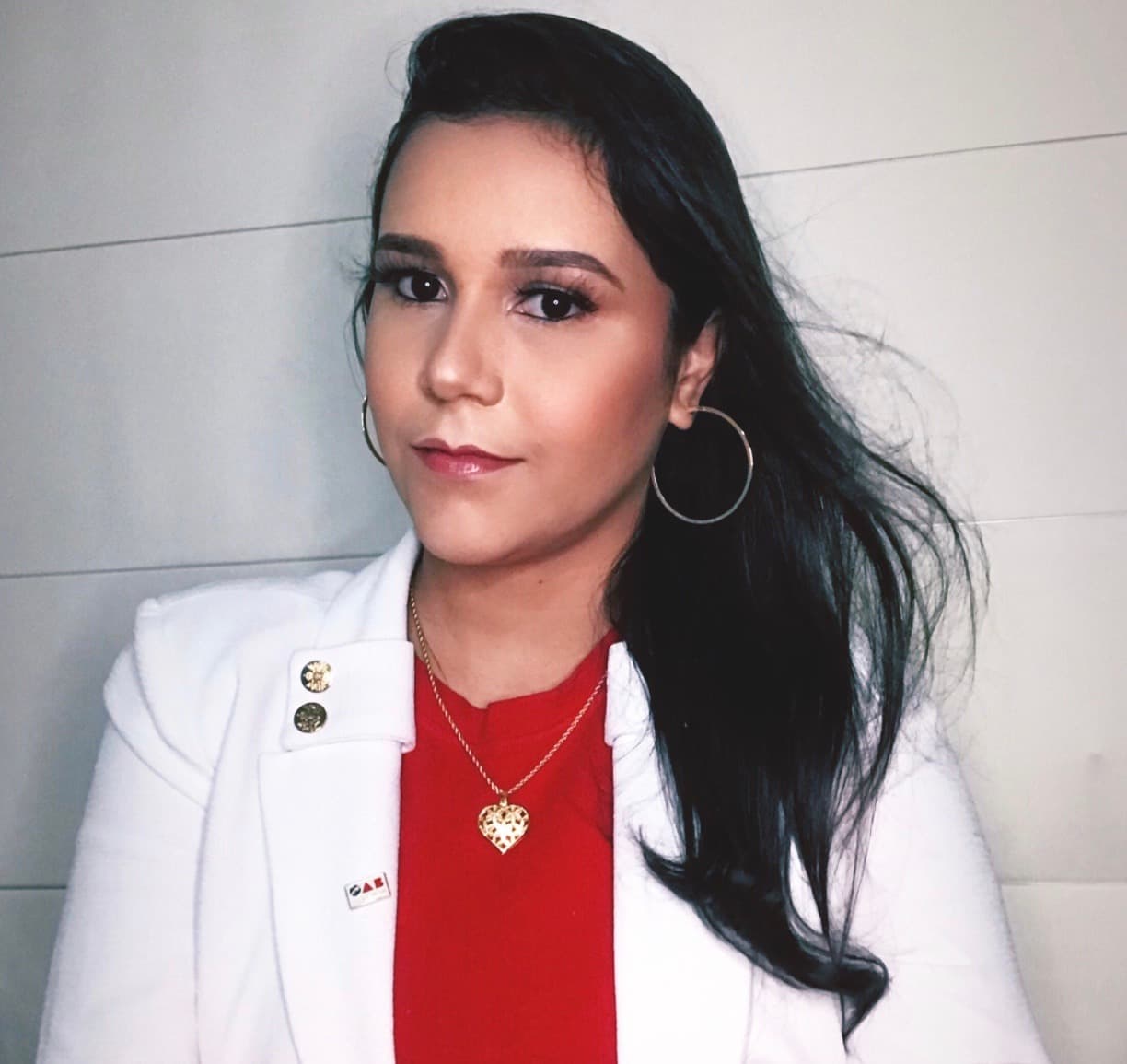 Uma mulher vestindo uma jaqueta branca e uma camisa vermelha