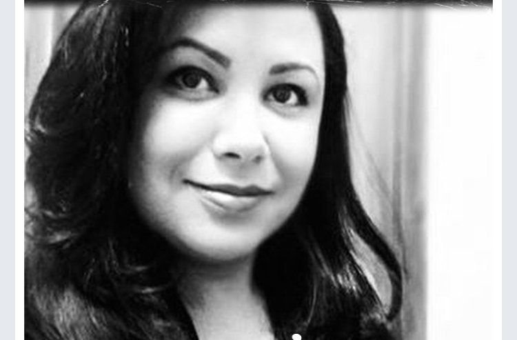 Uma foto em preto e branco de uma mulher com cabelos longos sorrindo.