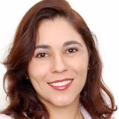 Uma mulher com longos cabelos castanhos está sorrindo para a câmera.