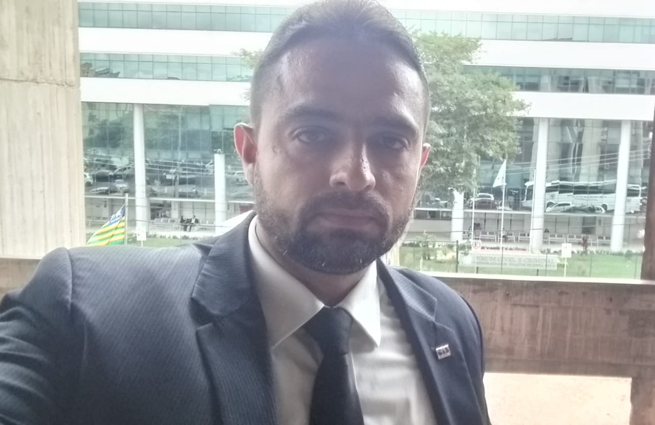 Um homem de terno e gravata está tirando uma selfie.