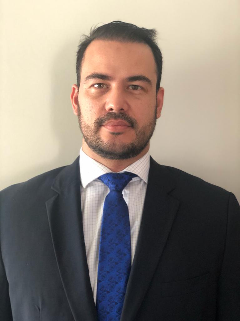 Um homem com barba está vestindo terno e gravata.