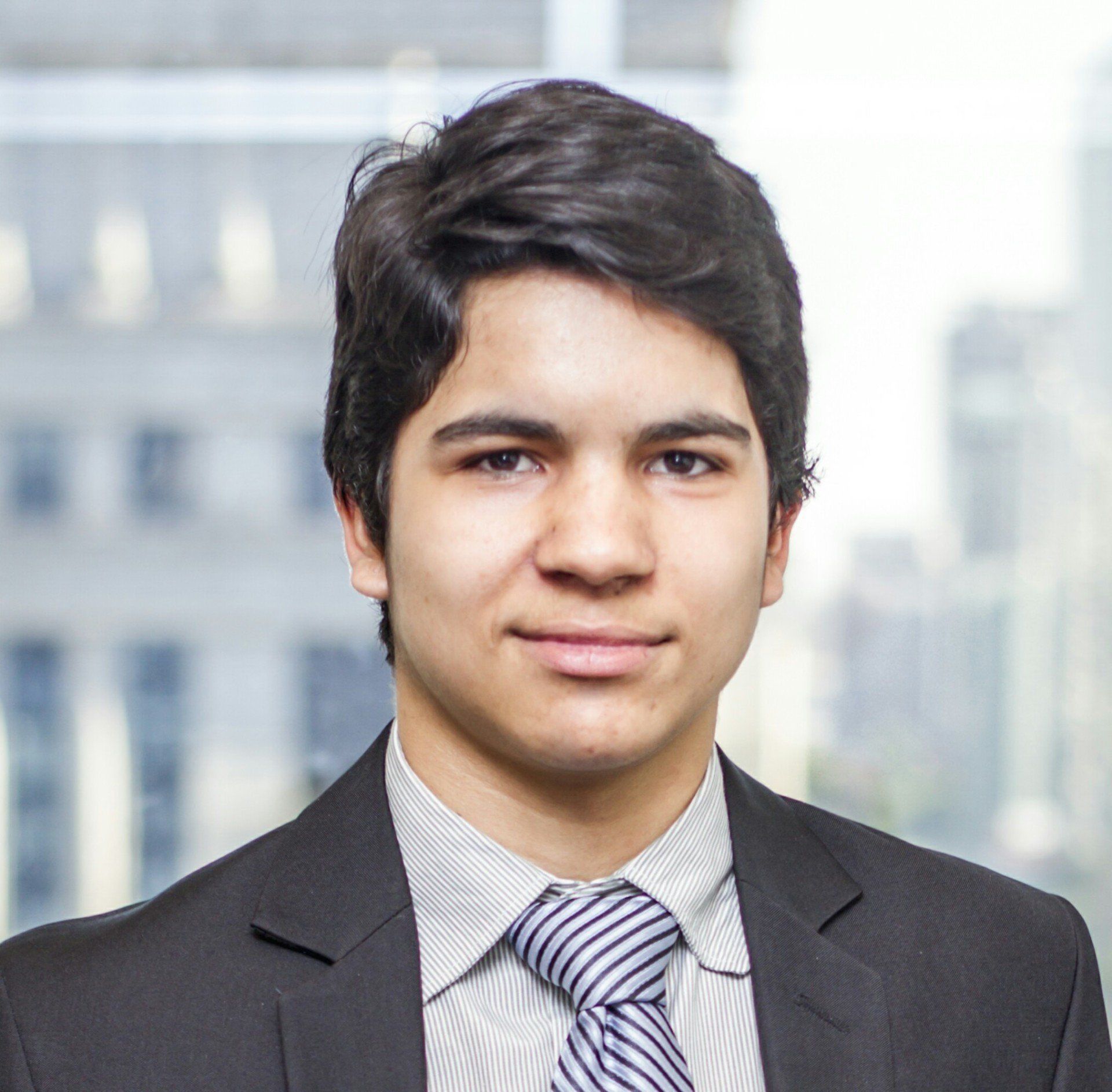 Um jovem de terno e gravata posa para uma foto