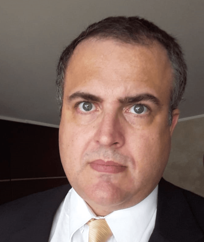 Um homem de terno e gravata está olhando para a câmera