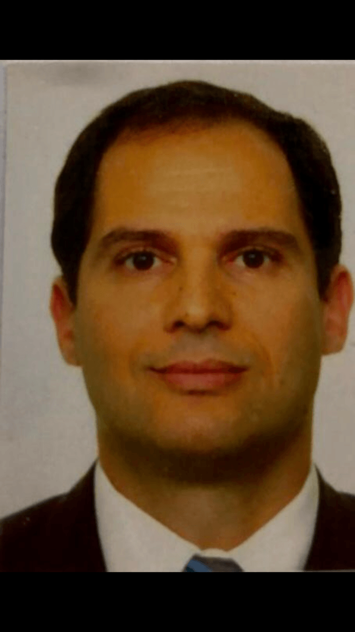 Um homem de terno e gravata está sorrindo para a câmera