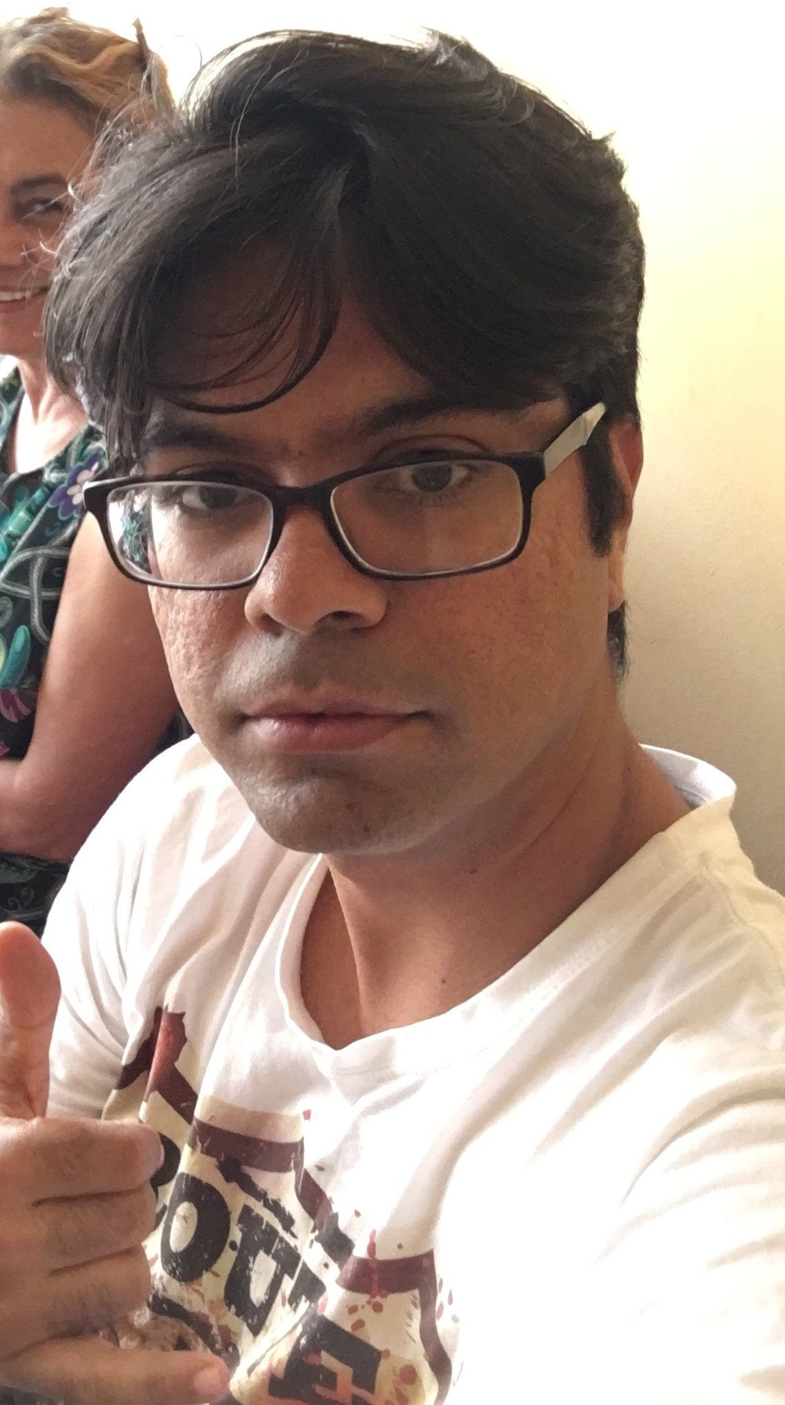 Um homem de óculos está fazendo sinal de positivo