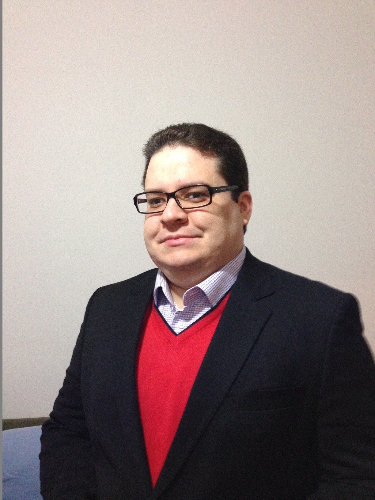 Um homem de óculos e um suéter vermelho