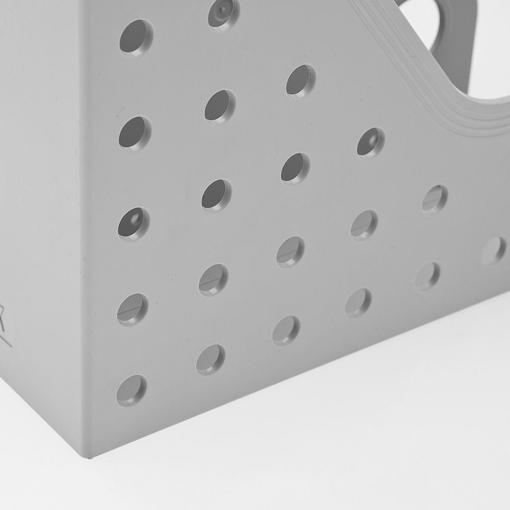 Un primer plano de un revistero gris con agujeros.