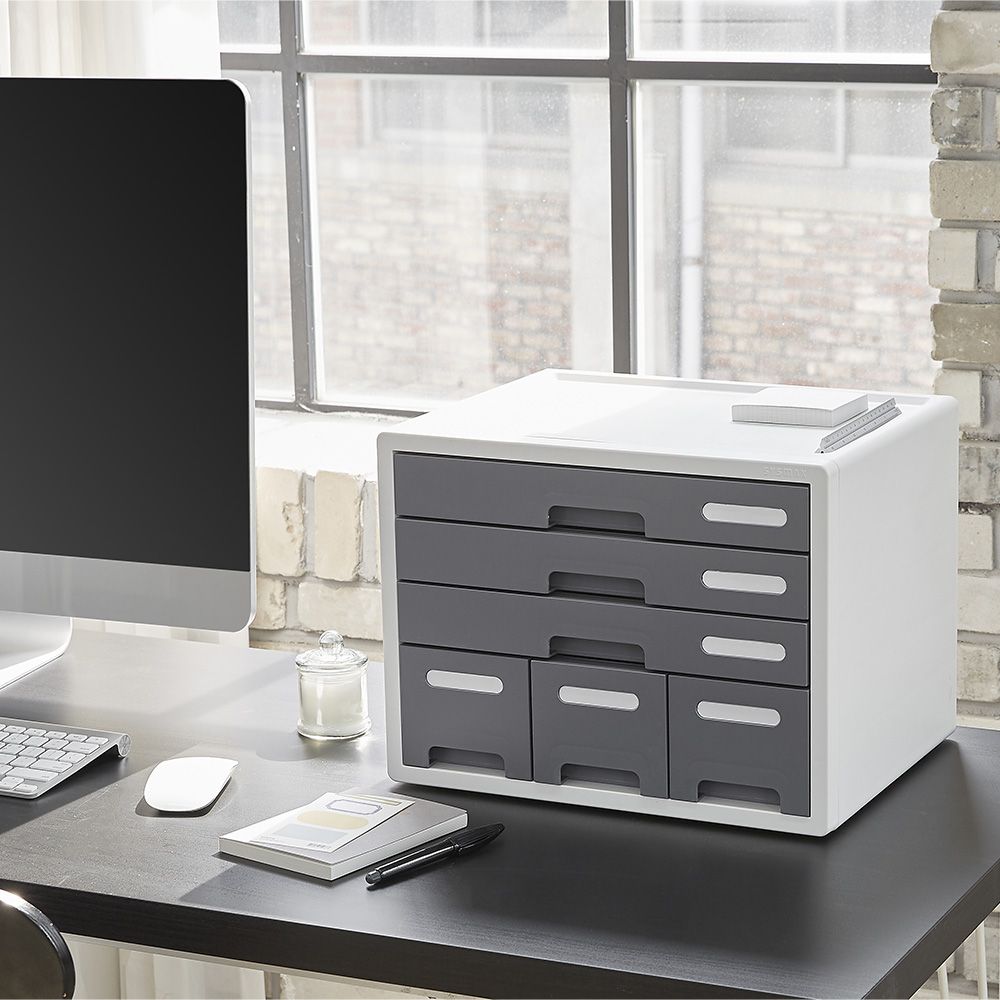 Una mesa con un ordenador y un cajón encima.