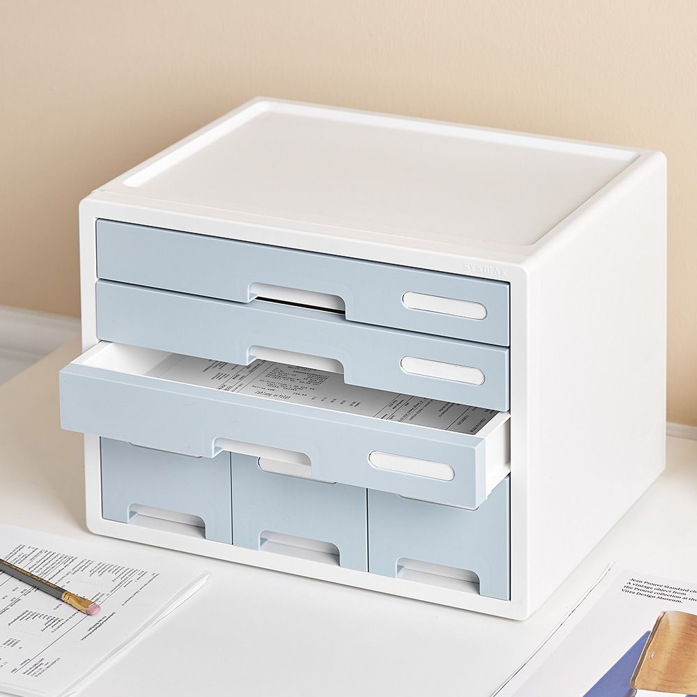 Un organizador de cajones blanco y azul está encima de una mesa.