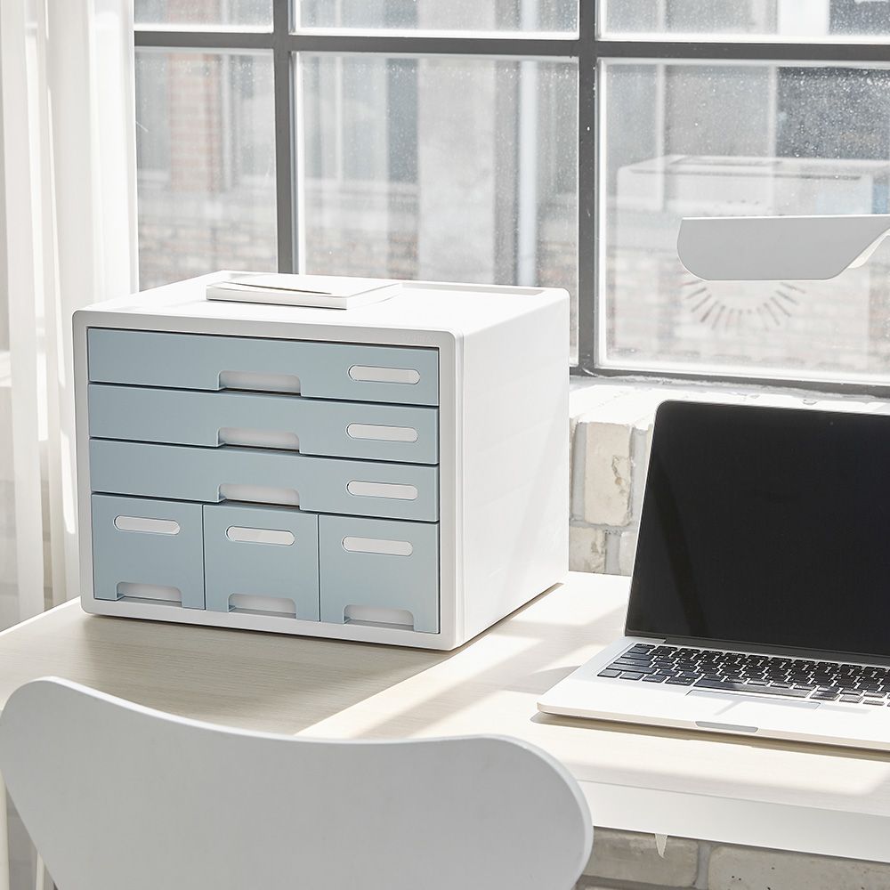 Hay un ordenador portátil sobre una mesa junto a una ventana.