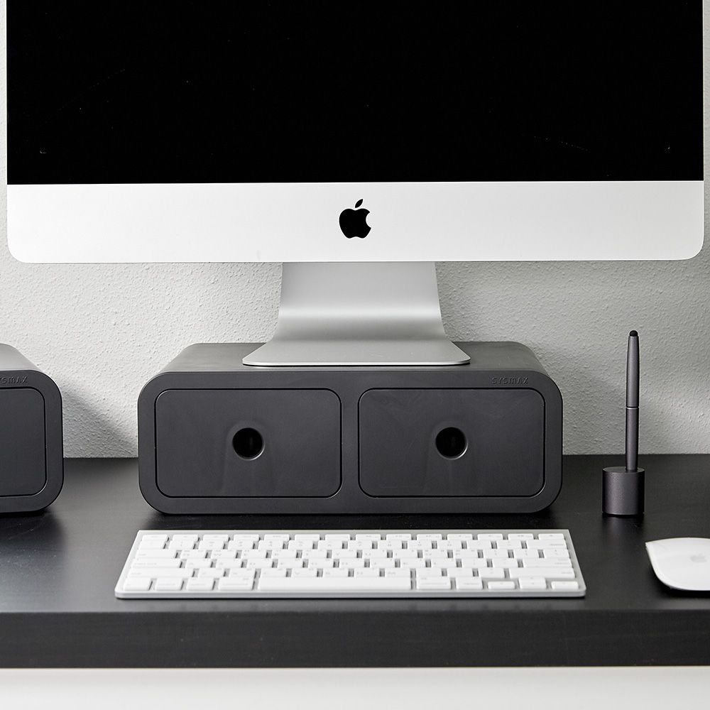 Um computador Apple está em cima de um organizador de mesa com gavetas