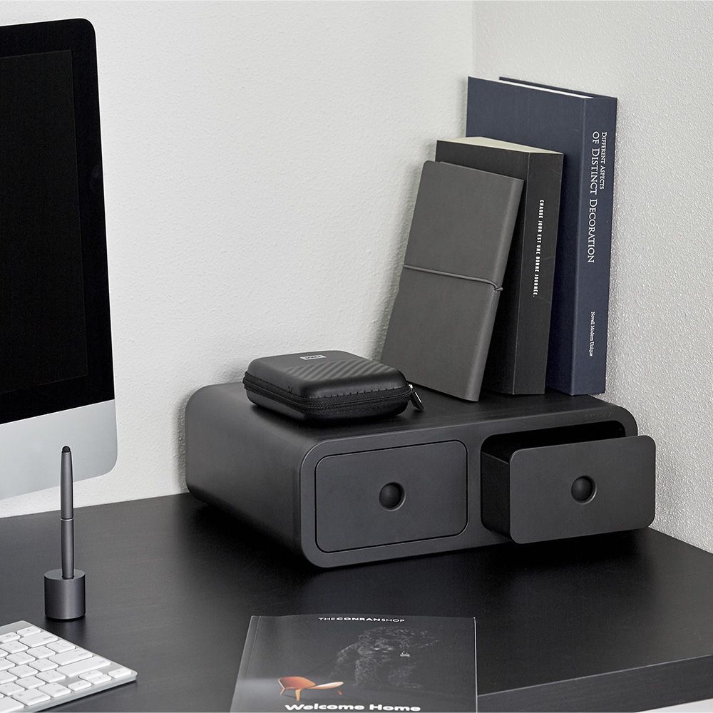 Una mesa con un ordenador y un libro titulado Bienvenido al hogar.