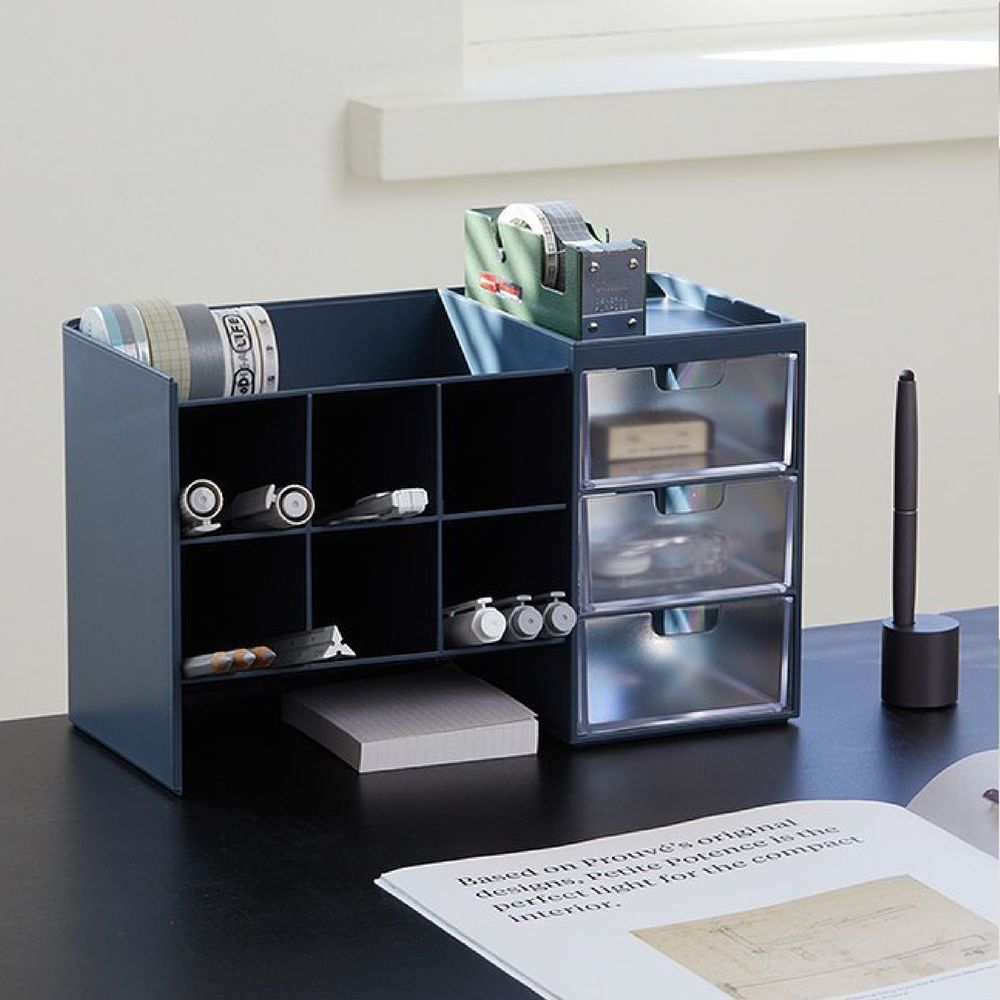 Un organizador de mesa con un bolígrafo y un trozo de papel encima.