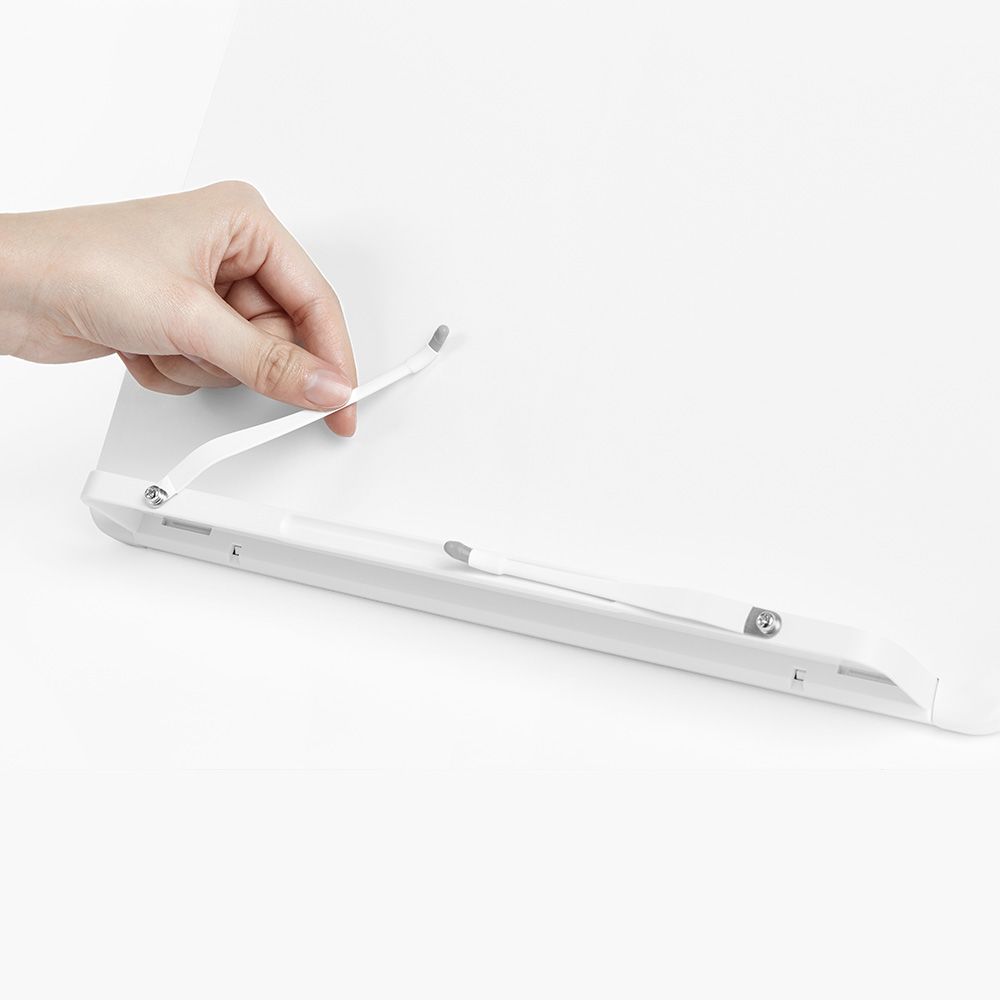 Una persona sostiene un soporte de estantería blanco en la mano.