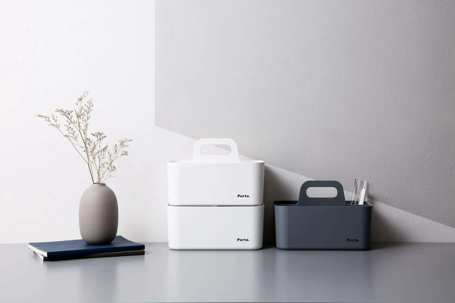 Una mesa con tres cajas y un jarrón encima.