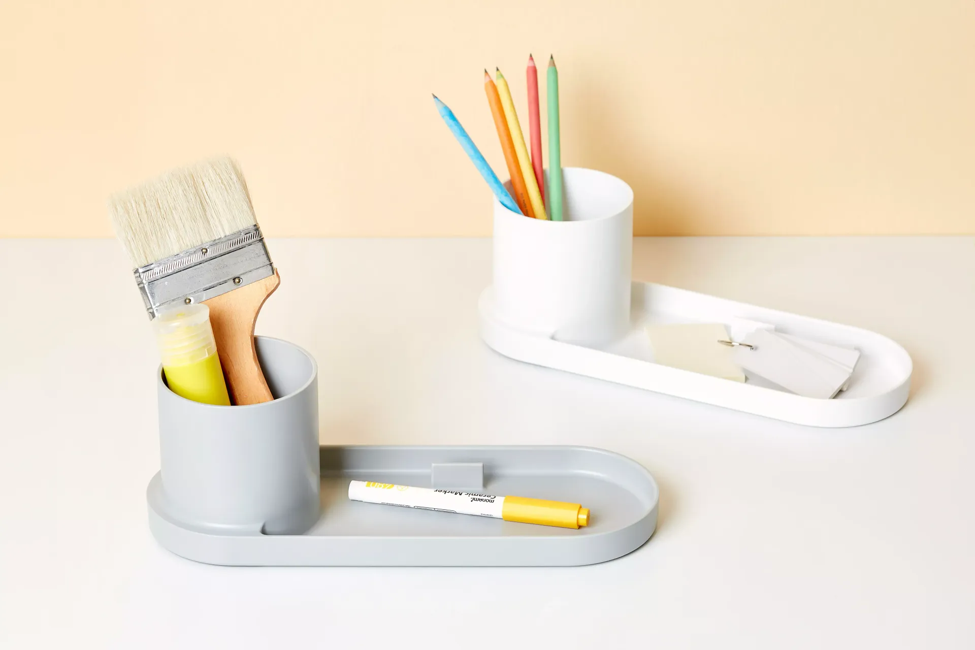 Un pincel y un lápiz están en un soporte sobre una mesa.
